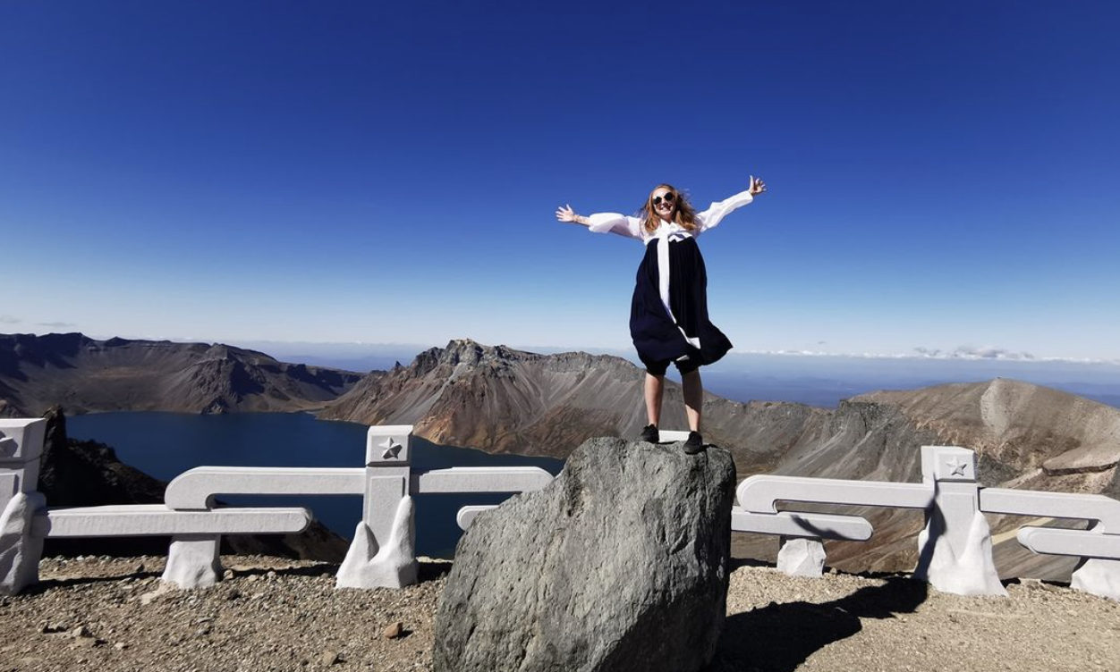 zoe discovers wearing a hanbok in north korea at the top of mt paektu to see Lake Chon.